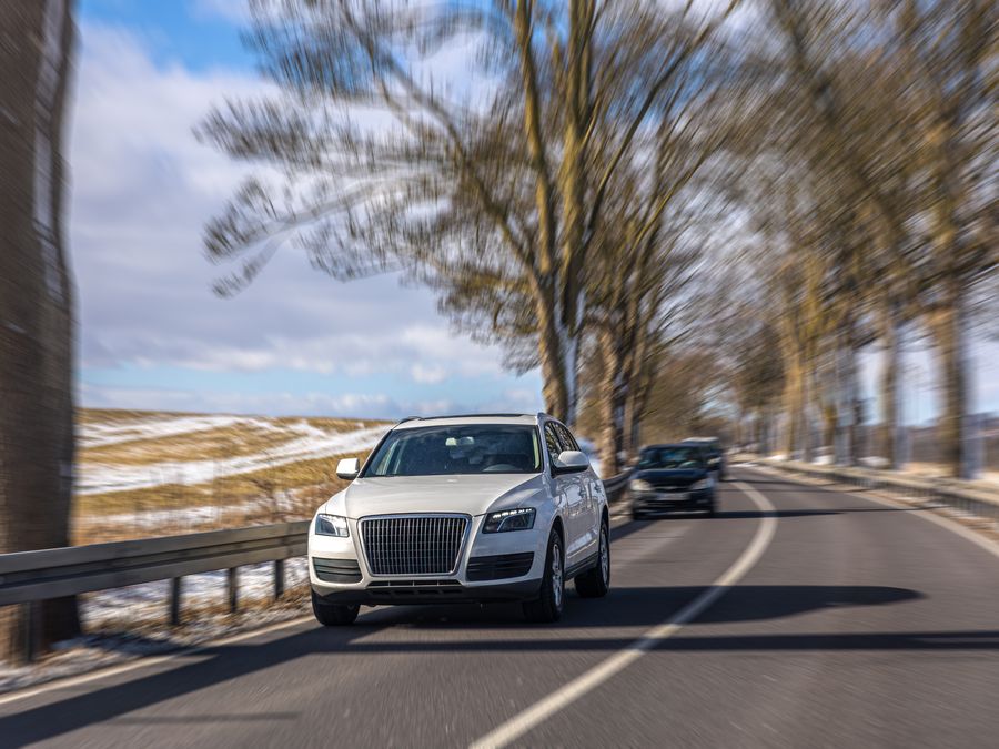 White SUV on a winding road — 6-seater rides for groups and families